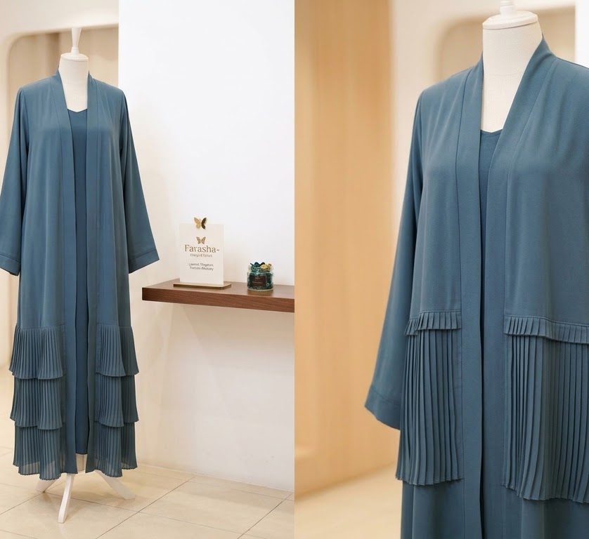 Teal open abaya with pleated hem, displayed in the boutique